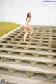 A woman in a bikini standing on a set of stairs.